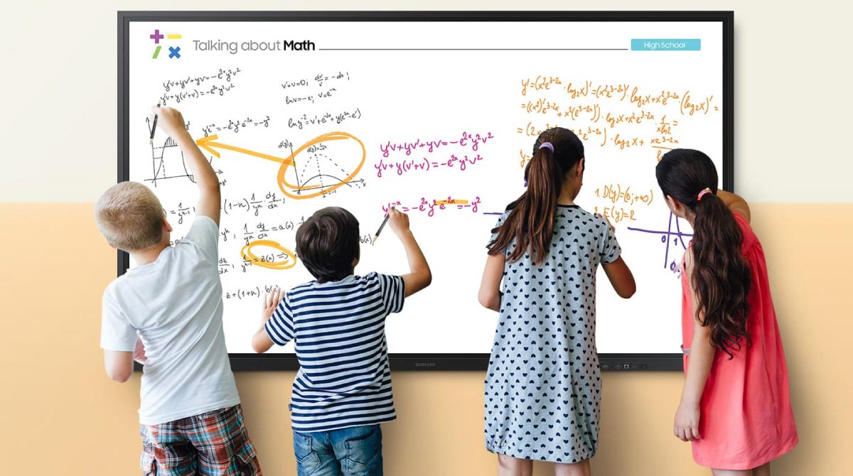 Bambini e bambine in classe svolgono esercizi di matematica su una lavagna multimediale interattiva