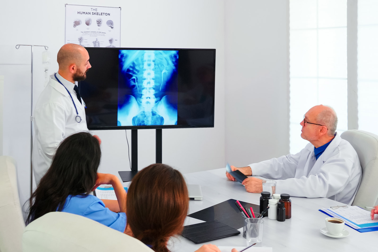medici in riunione valutano una radiografia sullo schermo di un monitor
