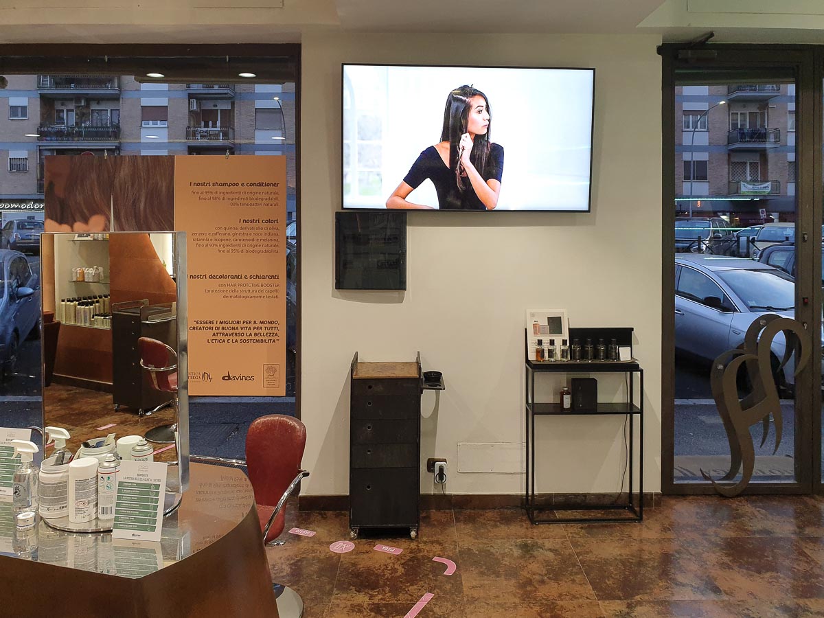 Display Samsung Smart Signage monitor tv installato all'interno del salone parrucchiere uomo donna