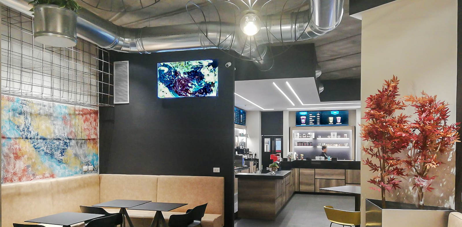 Videowall Samsung Smart Signage con menu prodotti installati a parete all'interno del bar caffetteria
