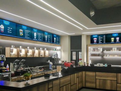 Videowall Samsung Smart Signage con menu prodotti installati a parete all'interno del bar caffetteria